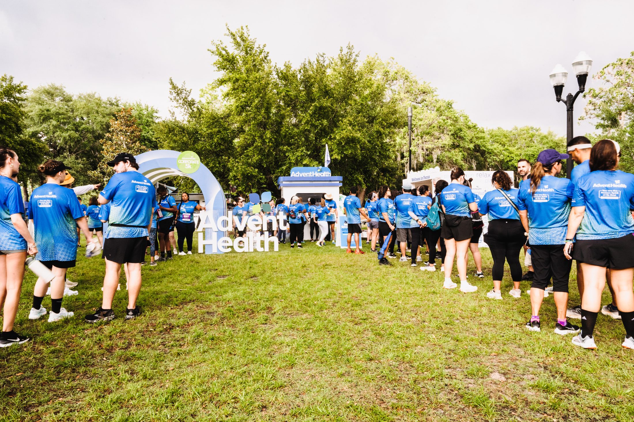 Crowd of runners gathered at the AdventHealth Corporate 5K branded arch