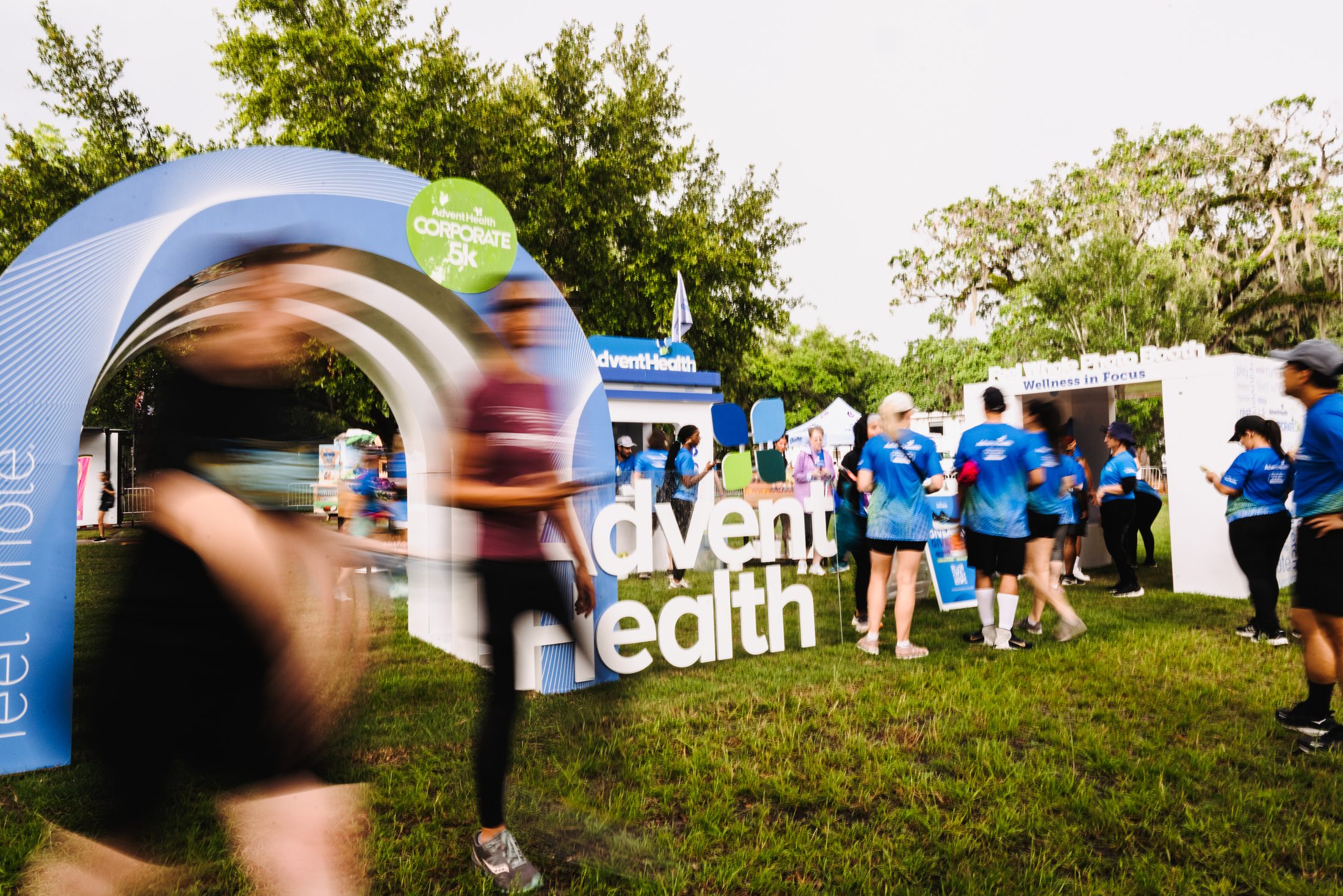 Runner moving through the AdventHealth Corporate 5K branded arch