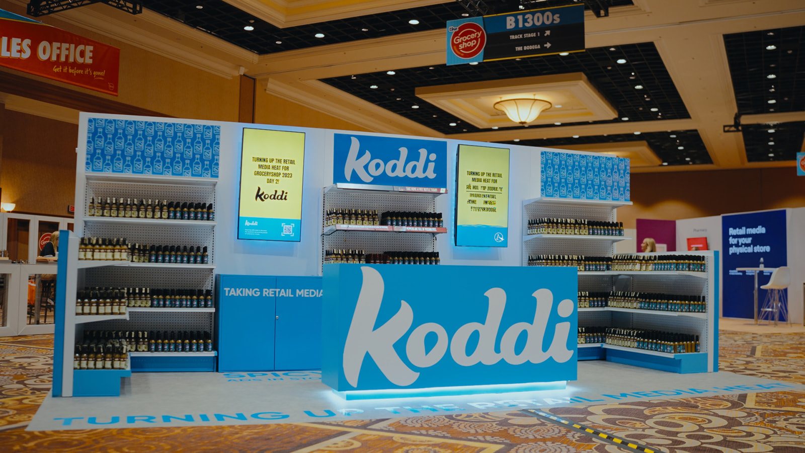 Koddi grocery-shelf booth at Groceryshop with Taking Retail Media branding